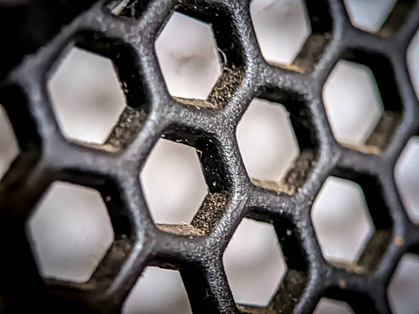 istock Close-up of a hexagonal mesh filter with visible wear and rough texture. The repeating pattern and surface details create an industrial, geometric aesthetic. 2222006991