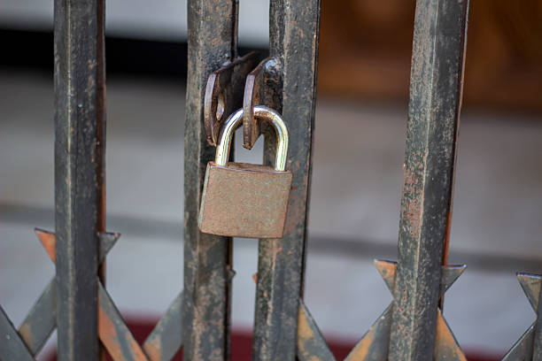 istock A padlock hangs in front of a black iron door. 2222008397