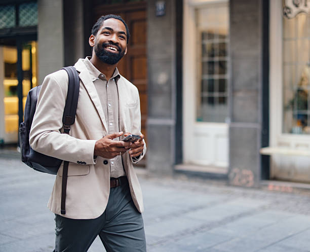 istock Young Professional Man Smiling While Holding a Smartphone Outdoors 2222011168