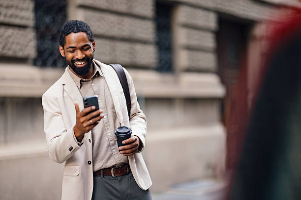 istock Professional Man Smiling with Smartphone and Coffee Outdoors in Urban Setting 2222011206