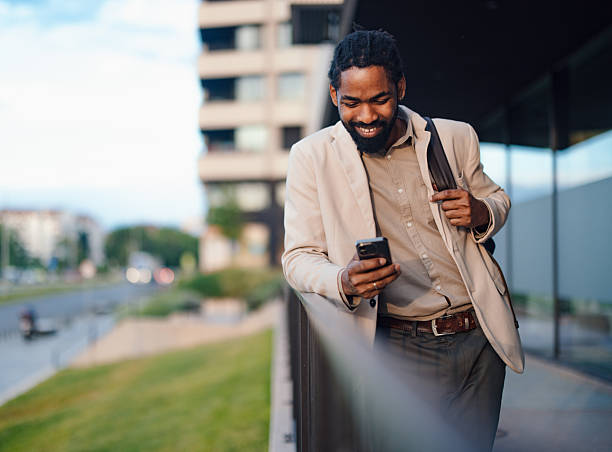 istock Smiling Businessman Outdoors Checking His Phone While Walking Near Buildings 2222011234