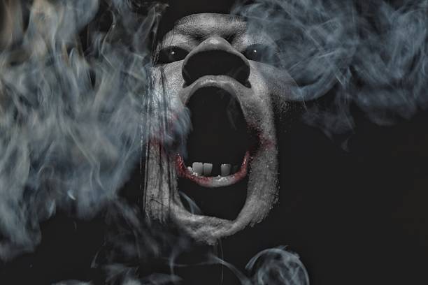 istock Terrifying Screaming Face Surrounded by Smoke in Dark Horror Scene 2222011348