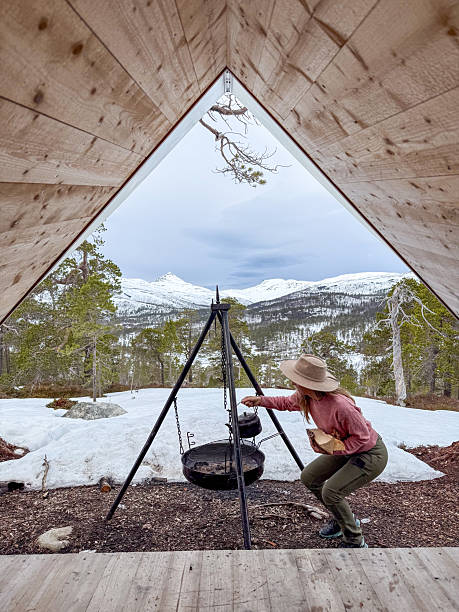 istock Woman Cooking Over Open Fire in Mountain Cabin Setting 2222012179
