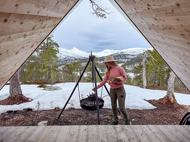 istock Woman Cooking Over Open Fire in Mountain Cabin Setting 2222012182