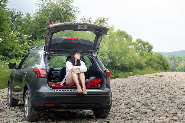 istock Woman Relaxing in SUV Trunk on Rocky Path 2222014646