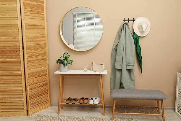istock Coat rack with clothes, mirror, shoe storage benches and folding screen in hallway. Interior design 2222015379
