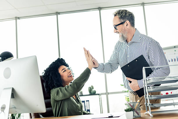 istock Professional colleagues celebrating success with a cheerful high five in a modern office environment 2222016041