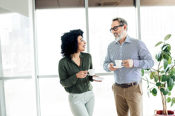 istock Professional colleagues chatting over coffee in a bright modern office space, fostering engagement and workplace collaboration. 2222016078