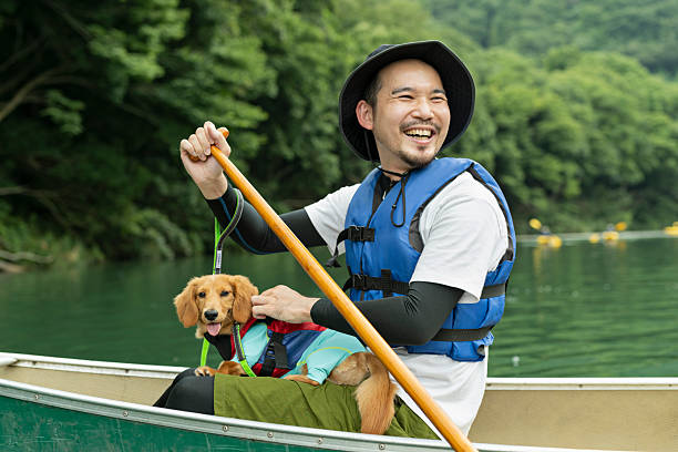 A man enjoying kayaking down a river with his dog