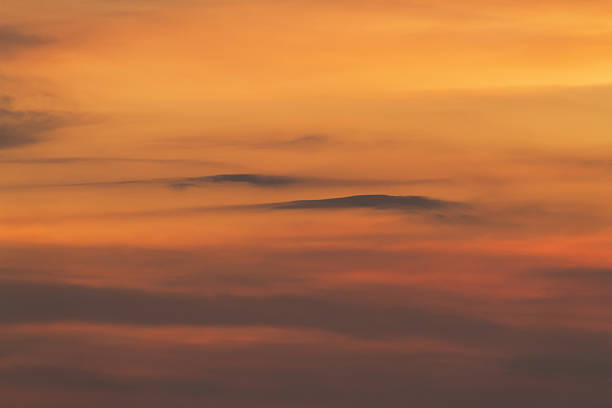 Dramatic orange and yellow sky with dark clouds at sunset