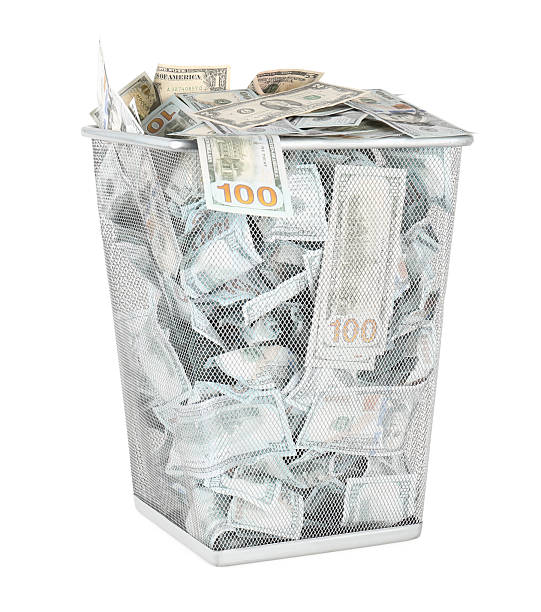 istock Many dollar banknotes in trash bin isolated on white 2222024706