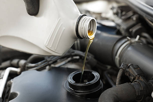 istock Man pouring motor oil into car engine, closeup 2222024707