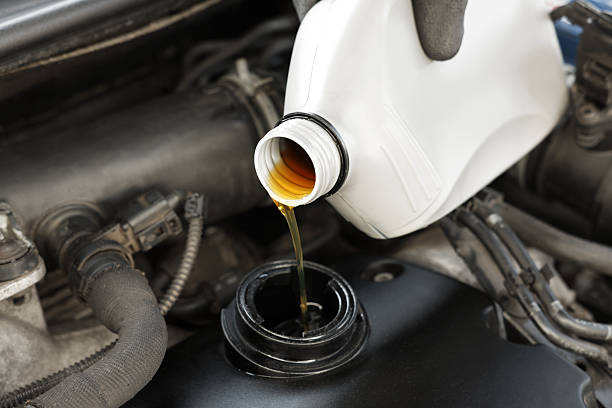 istock Man pouring motor oil into car engine, closeup 2222024718
