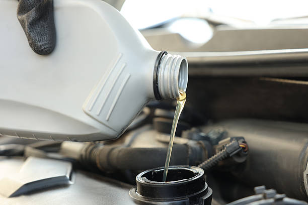 istock Man pouring motor oil into car engine, closeup 2222024719