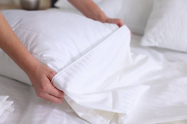 istock Woman changing clean bed linens at home, closeup 2222024840