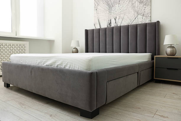 istock Bed with clean linens and bedside table at home 2222024866