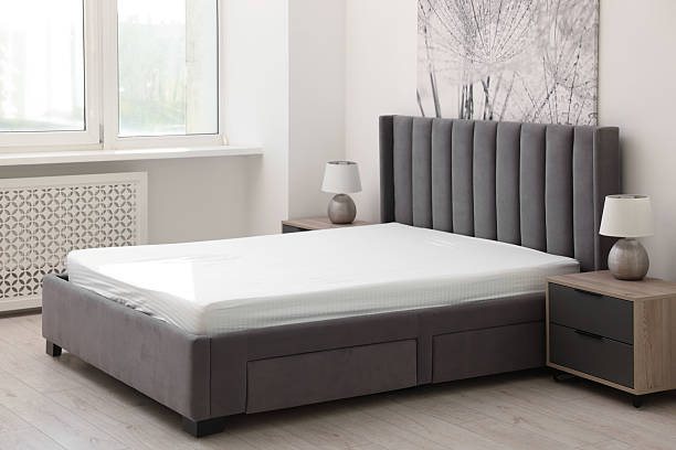 istock Bed with clean linens and bedside table at home 2222024930