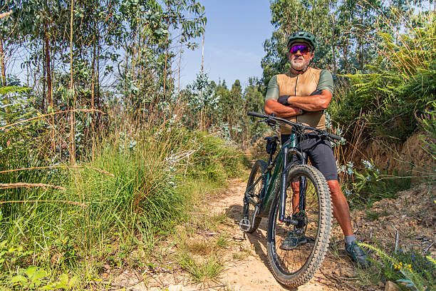 istock Senior cyclist taking a break on his e-bike in a forest trail 2222027997