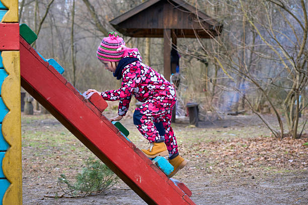 istock Cute child playing on the ladder at the playground 2222028366