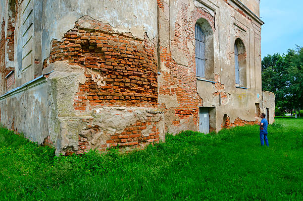 Bykhov, Belarus - June 18, 2025: Unidentified man looks at abandoned building of Bykhov Synagogue, Belarus