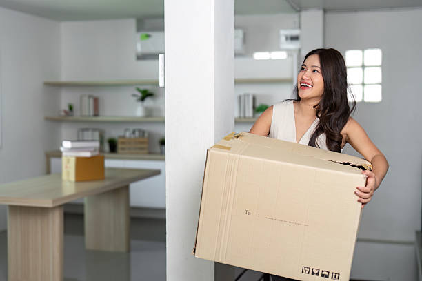 istock Moving Day: Woman Carrying Box with Joy in New Home 2222029861