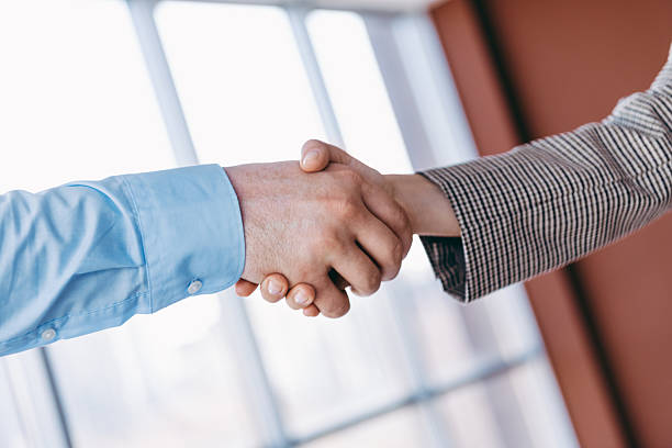 istock Young specialist handshake in a modern office environment representing agreement, partnership, and professional collaboration. 2222033173