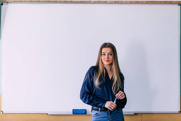 istock Female teacher at the marker board in classroom. Education conce 2222033778