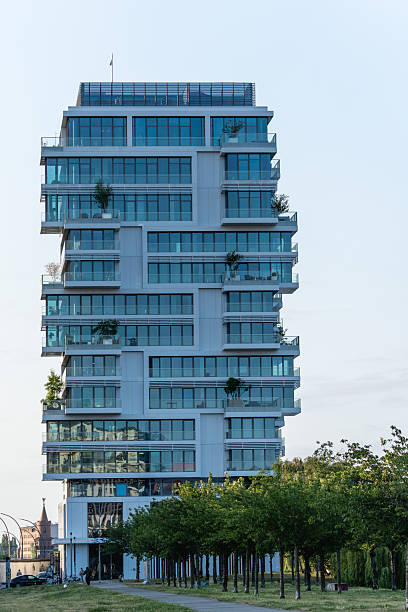 istock Modern glass apartment tower with staggered balconies and integrated greenery. 2222038012