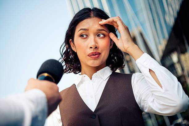 istock Confident businesswoman interviewed outdoors in urban setting with microphone, showcasing professionalism 2222039062