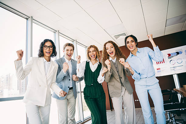 istock Successful diverse professionals celebrating teamwork with enthusiasm in a modern office, symbolizing corporate achievement 2222039677