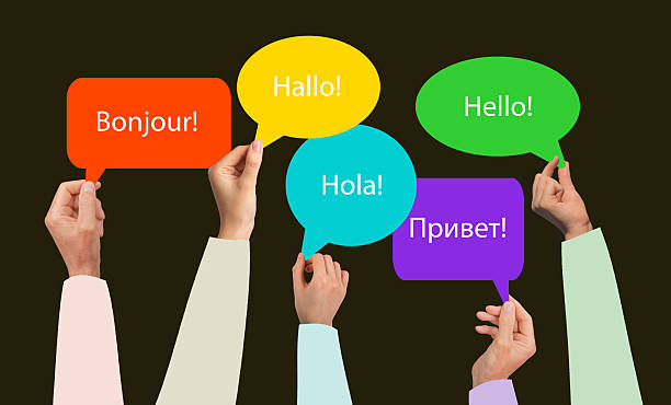 istock Hands group holding diverse speech bubbles with Hello in various languages. French, English, Spanish 2222042898