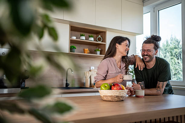 istock Happy couple laughing and drinking coffee in modern kitchen 2222047797