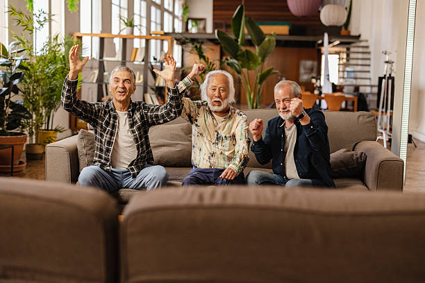 istock Group of retired men cheering while watching tv at home 2222047982