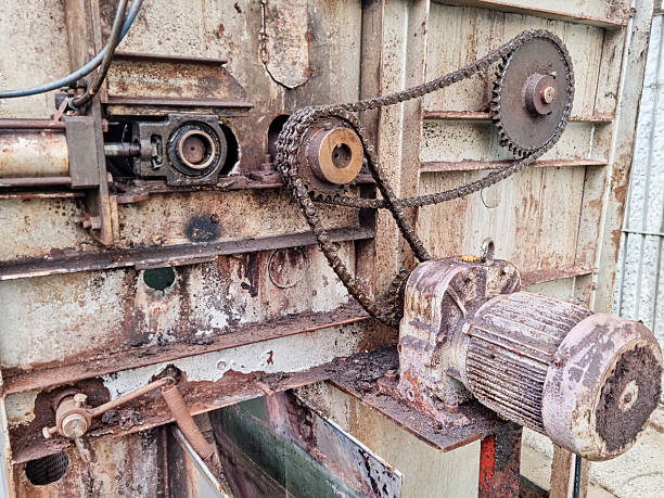 istock Rusty industrial motor with chain-driven gear system in a weathered factory setting. Features signs of corrosion, worn components, and vintage mechanical equipment in need of maintenance. 2222048518