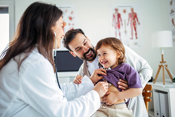 Caring Doctor Performing Chest Check on Child with Dad Present