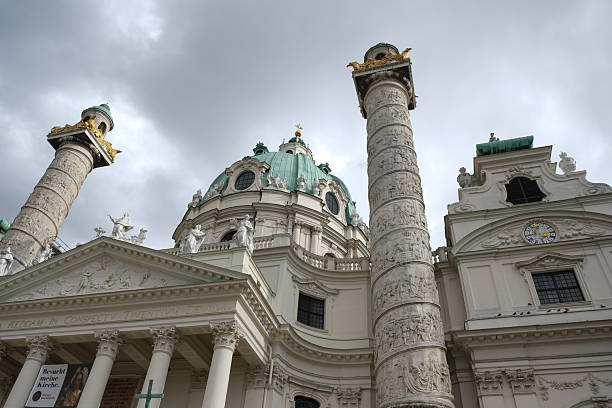 Shot of the ornate façade and emerald dome of Karlskirche (St. Charles Church) echo Baroque brilliance. Flanked by intricately carved victory columns modeled after Trajan’s Column in Rome, the church radiates imperial grandeur and spiritual symbolism. Sculptures of saints, classical pillars, and golden accents evoke both awe and reverence, inviting quiet reflection amid the bustle of the city.Concept :Karlskirche, St. Charles Church, Vienna architecture, Baroque design, imperial elegance, domed church, Austria travel, sacred grandeur, Roman columns, historic European churches, baroque statues, cultural heritage, spiritual travel, majestic facades, classical architecture