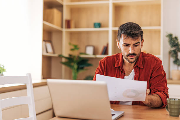 istock Focused freelancer analyzing charts and working on laptop at home office 2222054289