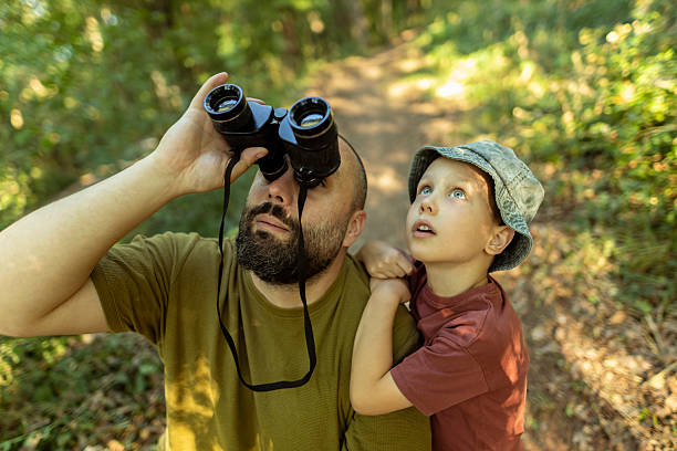 istock Father and son exploring birdlife, observing their movement and behavior in nature. 2222059497