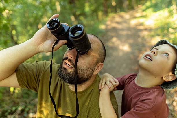 istock Father and son exploring birdlife, observing their movement and behavior in nature. 2222059525