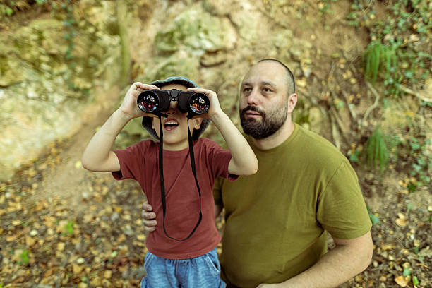istock Father and son birdwatching together using binoculars. Quality time, bonding moment in nature. 2222059530