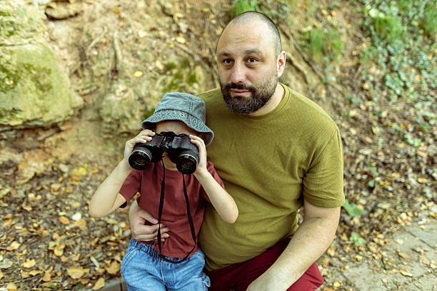 istock Father and son birdwatching together using binoculars. Quality time, bonding moment in nature. 2222059549
