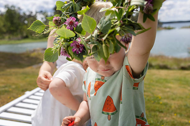 Close-up of a blond child wearing a colorful flower crown.
