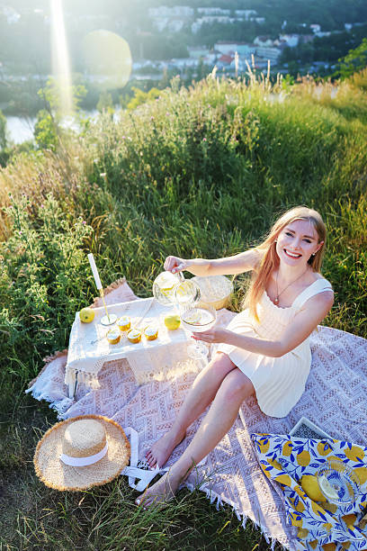 istock Elegant outdoor picnic setup with a smiling woman and refreshing drinks 2222062897