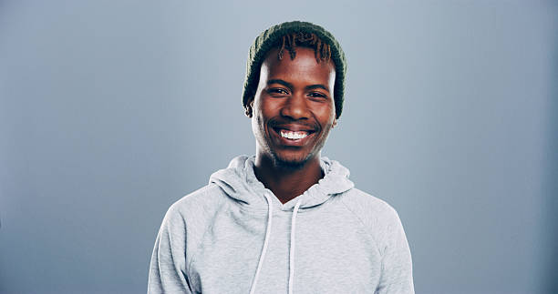 istock Black man, student and portrait in studio with smile, education ambition and fun opportunity. University scholarship, ID card and person on gray background space for registration process and happy 2222063764