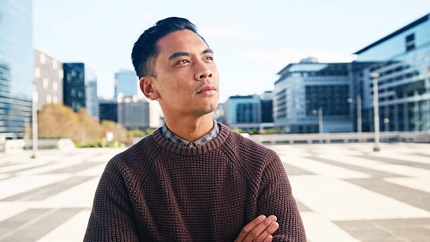 istock Pensive Man Posing in Urban Cityscape with Modern Architecture and Bright Sky Background 2222064105