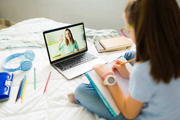 istock Little girl taking notes while learning online with her teacher 2222065303