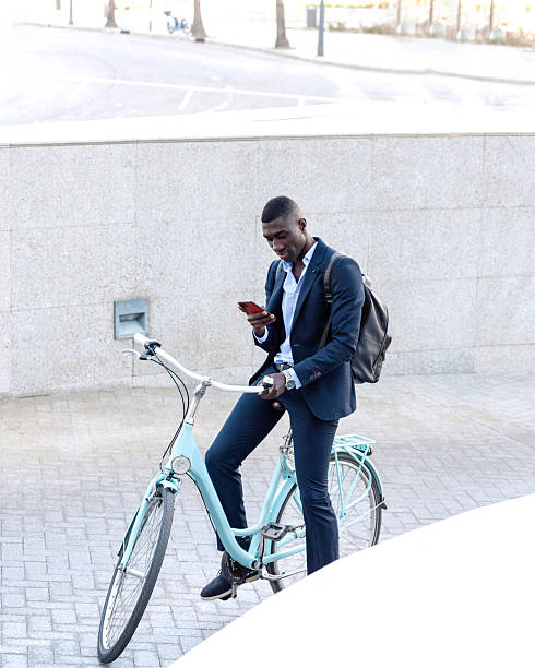 istock African american Businessman using smartphone while sitting on bicycle,sustainable transportation 2222065357
