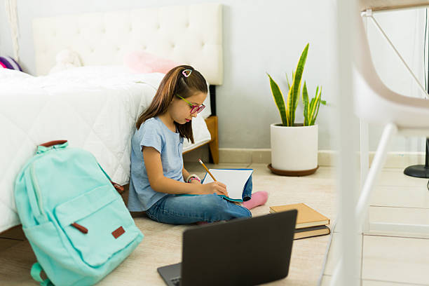 istock Young girl doing homework and taking notes in her bedroom 2222065995