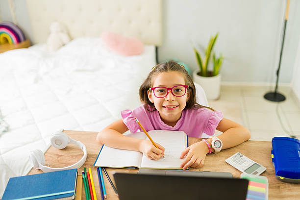 istock Happy latin girl doing homework and taking notes during online class at home 2222066222