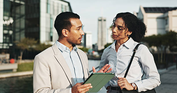 istock Corporate, people and explaining with tablet in city for planning, engineer team and urban development. Man, woman or talking with digital information, project management and infrastructure expansion 2222067274